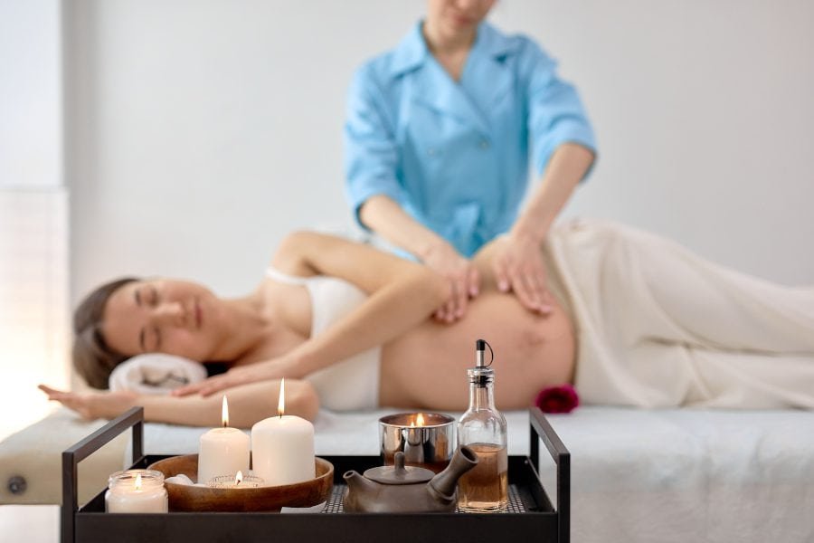 A pregnant woman relaxing while getting a prenatal massage