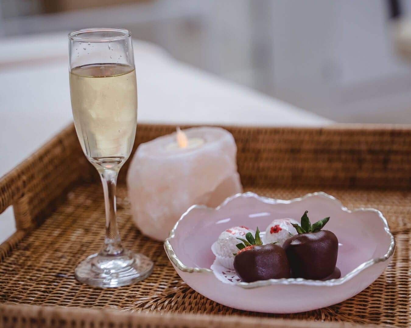 Choose a services at affordable price at Zen'd Out Massage Spa A woven tray holding champagne, a candle, and chocolate-covered treats