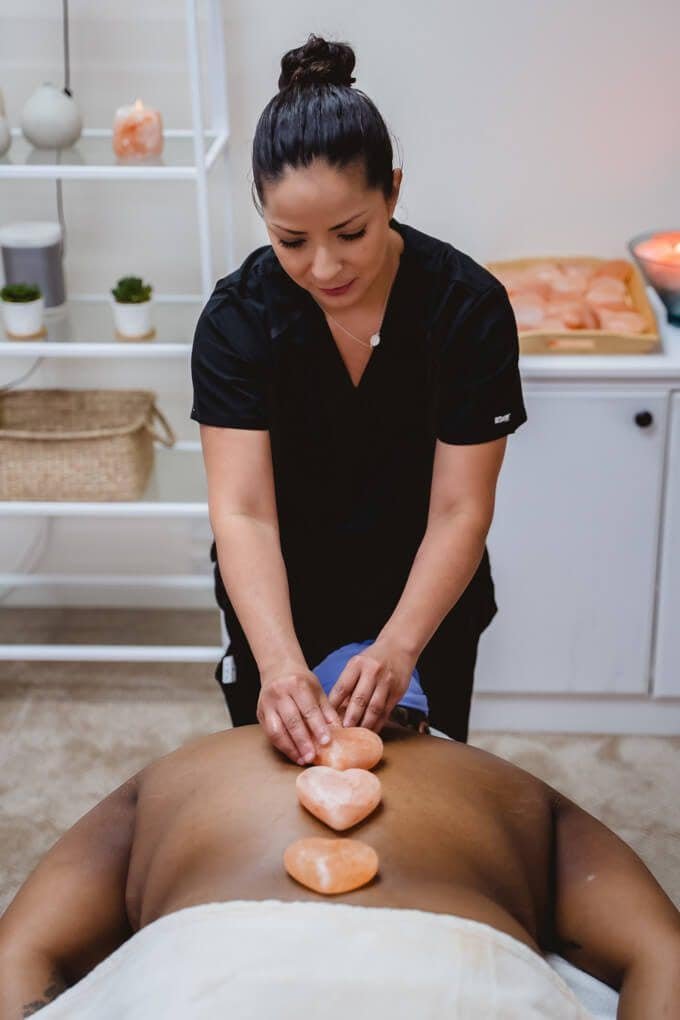 Himalayan Hot Stone Massage at Zen'd Out Massage Spa A therapist performing a hot stone massage on a client