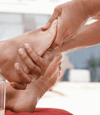 A therapist performing a reflexology massage on a client.