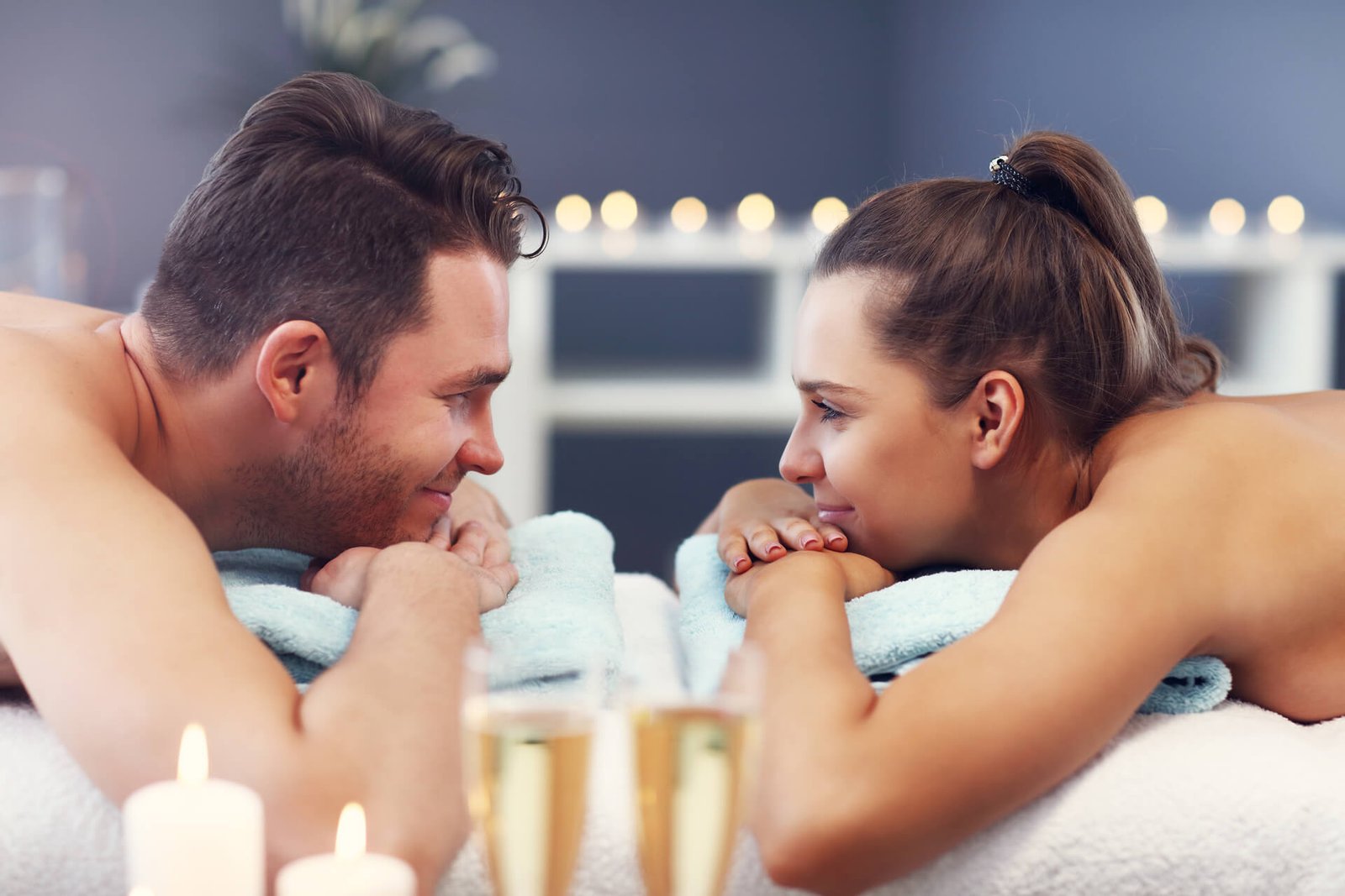 Why Choose Zen’d Out Couples Massage Spa A couple smiles at each other while relaxing together during a spa treatment.