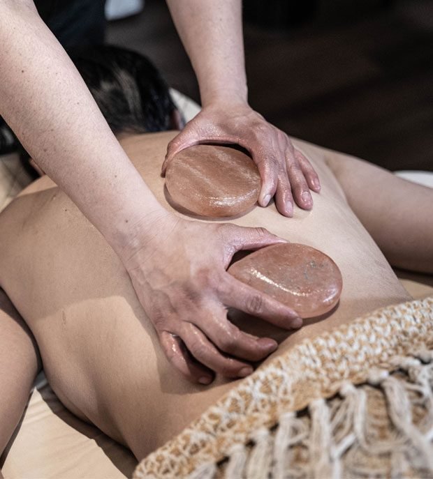Heated stones placed along the back during a hot stone massage