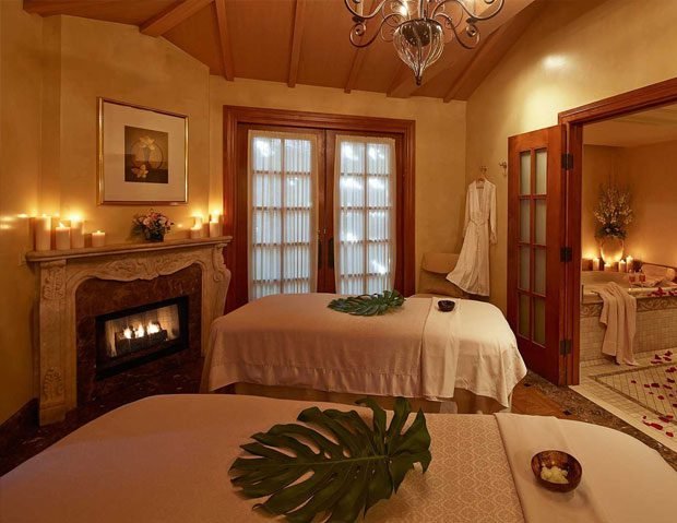 Luxurious candlelit spa room featuring two massage tables at Zen’d Out Englewood