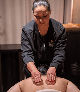 Hot stone massage A therapist perfoming a hot stone massage on a man.
