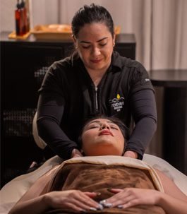 single-massag A woman relaxing while receiving a single massage hot stone treatment on her back.